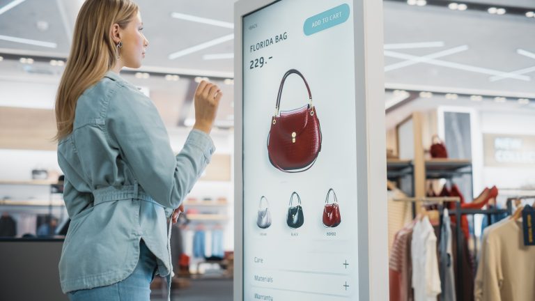 A shopper interacting with a digital retail media display, showcasing omnichannel retail marketing and shoppable media integration in a modern store.